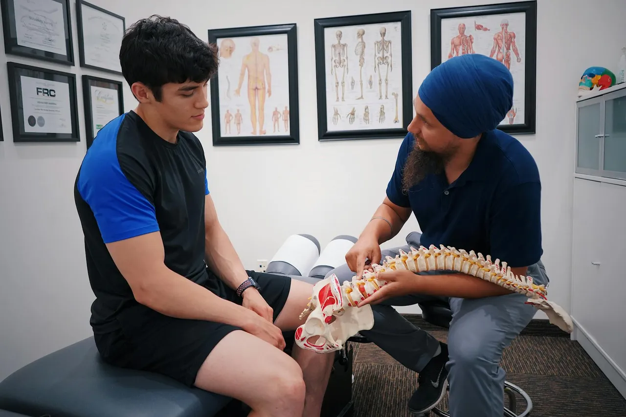 Physical therapist guiding a patient through a back strengthening exercise, focusing on core stability and proper form.